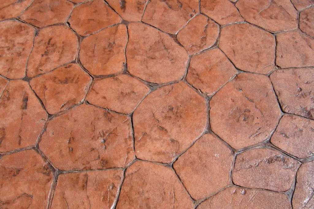 Terracotta-toned stamped and stained concrete surface detail