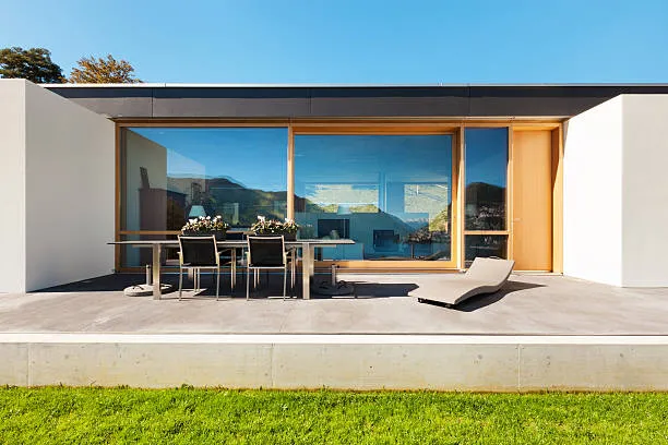 Modern Austin home with a smooth concrete patio and covered outdoor seating