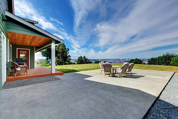 Finished concrete patio with outdoor furniture beside an Austin home