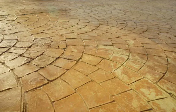 Fan-pattern stamped concrete driveway in a warm tan finish